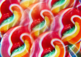 Close-up of swirly rainbow lollipop through prism filter