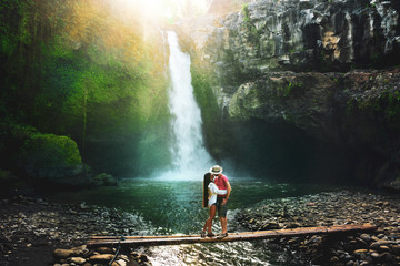 Active lifestyle couple travel in Asia and explore amazing waterfall hidden in tropical rainforest...