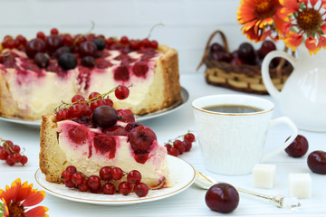 Cake with berries is located on a plate on a white background