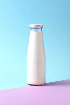 A bottle of white milk, covered with a cap, one full, isolated o