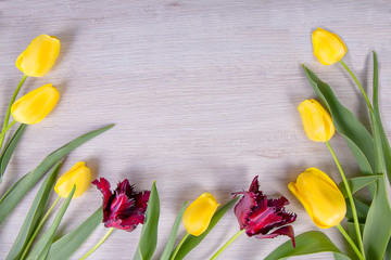 bouquet of yellow and purple tulips, on a light wooden background