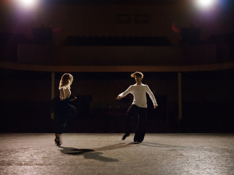 Dancing partners on stage in lights