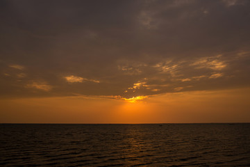 Fototapeta na wymiar Bright sunset with large yellow sun under the sea surface. sunrise in the sea. Beautiful sunset above the sea.
