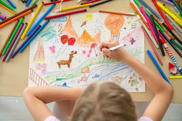 Child drawing with color pencils