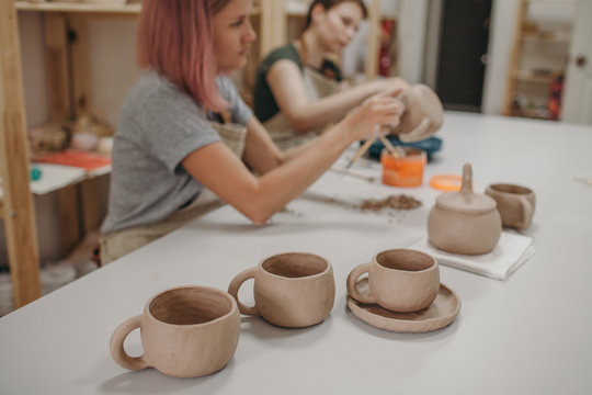 Two young women potter working in pottery studio