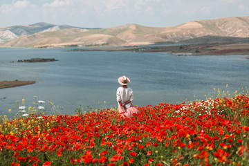 Young woman in a poppy field