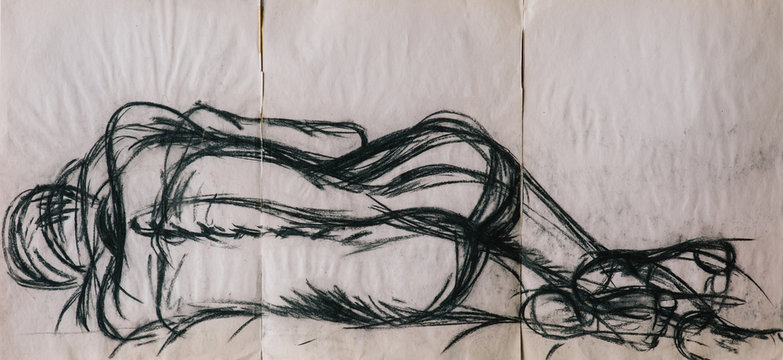Charcoal life drawing of a woman lying naked in a bed