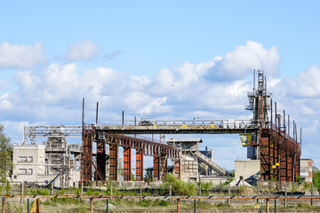 Fototapeta na wymiar Abandoned industrial building with rusty bridge crane at scrap metal recycling metallurgical plant