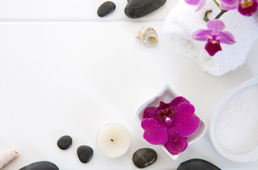 Fototapeta na wymiar Spa setting with pink orchids, black stones and bath salts on wood background.