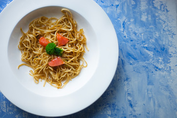 spaghetti with basil snd red salmon on the white plate