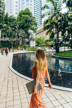 Woman with laptop walking thought plaza