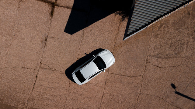 aerial view of a brand new car near an abandoned petrol station in the desert
