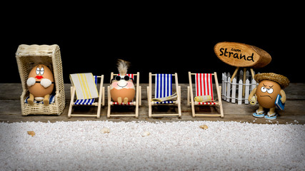 Hühnereier am Strand mit Liegestühlen