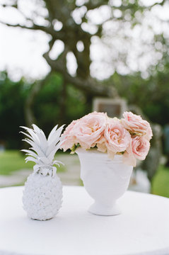 Outdoor tropical wedding guest table with pink flower arrangement