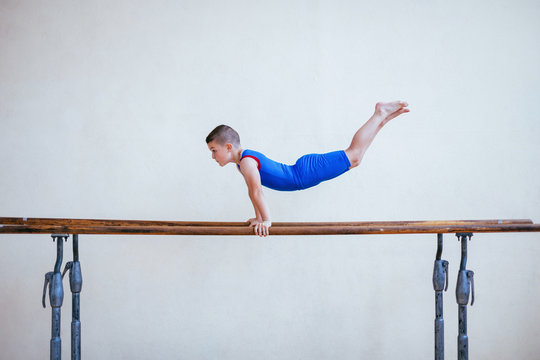 Side view of boy practicing on parallel bars