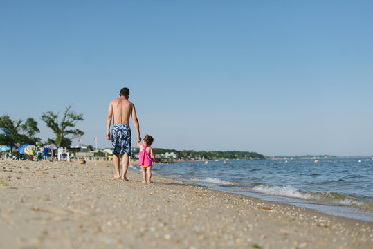 Dad and child walking on the beach