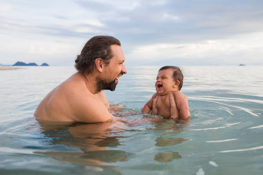 Smiling father and son swimming in sea