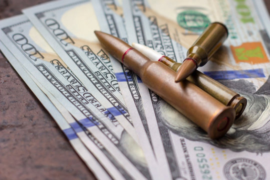 Weapon bullets on American dollars background. Military industry, global arms trade and crime concept