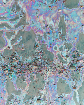 Colored water on stones and sand.Environmental pollution