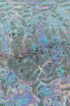 Colored water on stones and sand.Environmental pollution