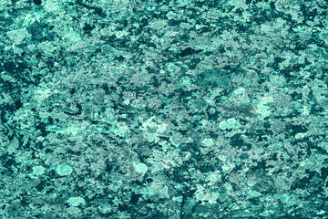 Vintage azure background. Rough painted wall of turquoise color. Imperfect plane of cyan colored. Uneven old decorative toned backdrop of aqzure tint. Texture of teal hue. Ornamental stony surface.