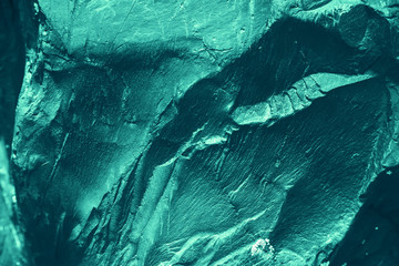 Vintage azure background. Rough painted wall of turquoise color. Imperfect plane of cyan colored. Uneven old decorative toned backdrop of aqzure tint. Texture of teal hue. Ornamental stony surface.