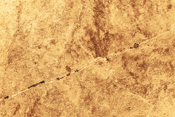Vintage yellow background. Rough painted wall of aspen gold color. Imperfect plane of golden colored. Uneven old decorative toned backdrop of yellow tint. Texture of gold hue. Ornamental stony surface