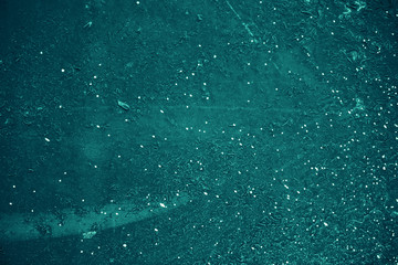 Vintage azure background. Rough painted wall of turquoise color. Imperfect plane of cyan colored. Uneven old decorative toned backdrop of aqzure tint. Texture of teal hue. Ornamental stony surface.