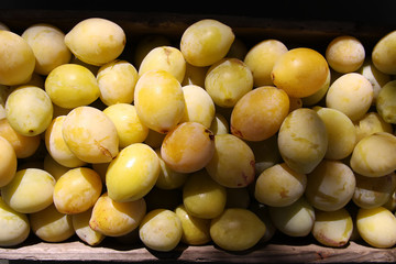 Fresh yellow plums. Ripe fruits in a wooden box in summer garden