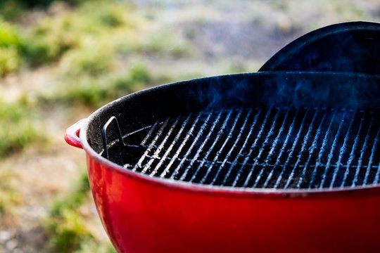 Red Barbecue Grill In The Backyard Ready For A Barbeque Party.