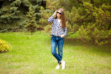 Obraz premium Relaxation in summer day. Young girl walk in park in sunglasses