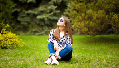 Fototapeta premium Relaxation in summer day. Young girl walk in park in sunglasses
