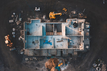 Aerial birds eye image of the frame of a house being built on a construction site at sunset -...