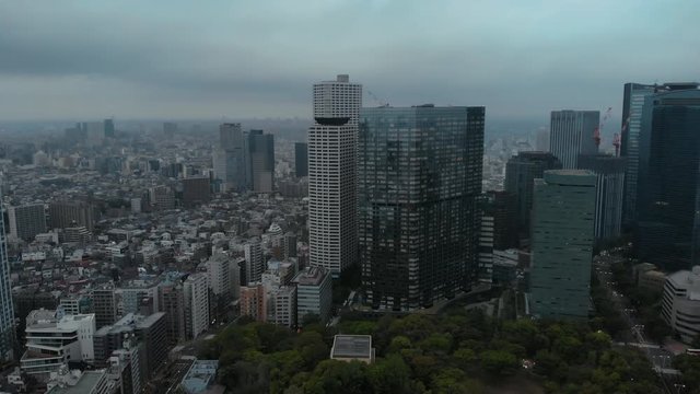 Tokyo, Shinjuku - descending over park - aerial shot , Cloudy Morning, Japan