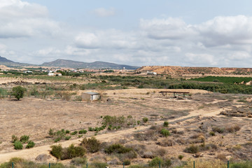 Fototapeta na wymiar Dry land, mountains and cloudy sky landscape, south of Spain