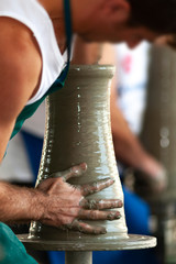 skilled hands, dirty with earth, model, mold and paint the clay, creating works of art