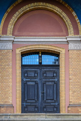 Fototapeta na wymiar old heavy wooden door at a brick house