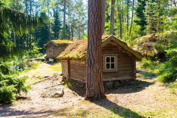 An old authentic 18th century wooden farmhouse in the middle of a forest on Seurasaari island in Helsinki in Finland on a summer day. Beautiful Finland.