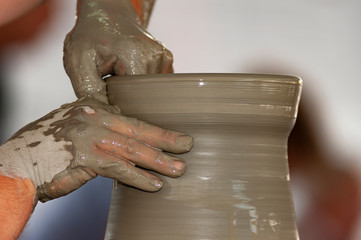 skilled hands, dirty with earth, model, mold and paint the clay, creating works of art