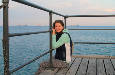 Girl sitting on a sea pier