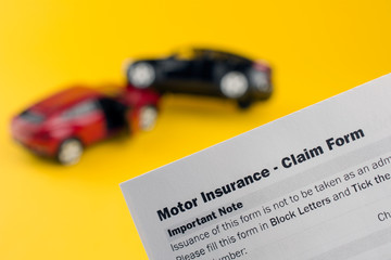 two broken cars and insurance document. direct line car insurance concept. yellow background