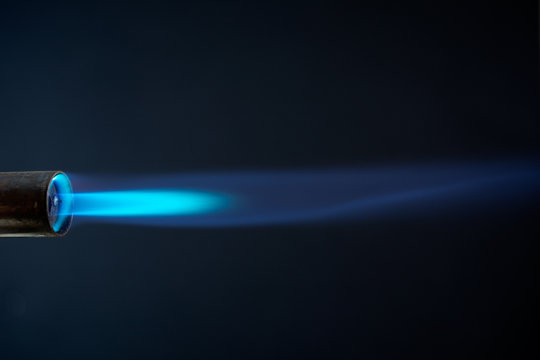 blowtorch blue flame close up dark background