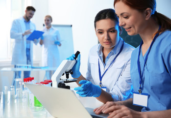 Group of scientists working in modern chemistry laboratory