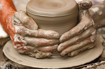 skilled hands, dirty with earth, model, mold and paint the clay, creating works of art