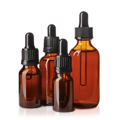 Cosmetic bottles of essential oils on white background