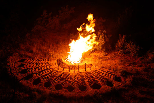 Bonfire with feather patterns in the dirt