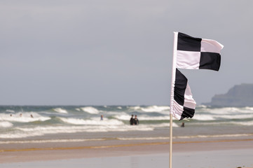 Black and white chequered surfers flag warning swimmers that surfers and kayaks are in the area