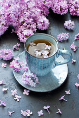 Obraz na płótnie Canvas Spring composition with tea cup and lilac flowers
