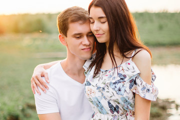 Portrait of happy couple outdoor in nature location at sunset.