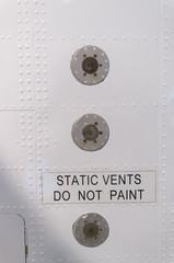 Static vents on the side of an airplane with a warning not to paint over them.